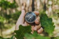 Compass in a guy s hand on the background of the forest. Concept on the theme of tourism