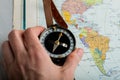 Compass in hand against the background of a bright world map