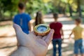 Compass in hand against the background of standing children in the forest