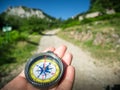 A compass and hand on road in mountains Royalty Free Stock Photo