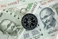 Compass on Indian Rupee banknotes money using as India economic problem solving, financial direction or key to get success in