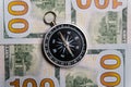 The compass lies on hundred-dollar cash bills. Close-up. Royalty Free Stock Photo