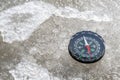 Compass is lying on the ice surface in a winter frosty day