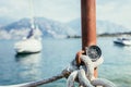 Sailing: nautical compass on a sailing rope, pier. Sailing boats in the background