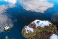 The compass is lying on the snow on the lake shore . The arrow points to the North