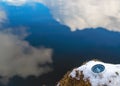 The compass is lying on the snow on the lake shore . The arrow points to the North