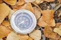 Compass lying in yellow autumn foliage.Concept recreation, travel, and tourism