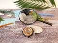 Compass, magnifier, notepad, pencil, sea stones, palm leaf on a textural wooden table