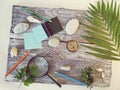 Compass, magnifier, notepad, pencil, sea stones on a textural wooden table