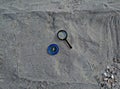 Compass and magnifier on sand