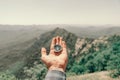 Compass on male hand in summer mountains, pov. Royalty Free Stock Photo
