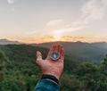 Compass on palm hand in summer mountains at sunrise. Royalty Free Stock Photo