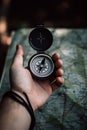 Compass and map in hands of traveler for checking and searching position and direction AI generated