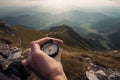 Compass and map in hands of traveler for checking and searching position and direction at the top of peak of mountain while hiking Royalty Free Stock Photo