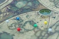 Compass and marking pins on blur vintage map, journey concept Royalty Free Stock Photo