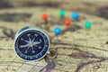Compass and marking pins on blur vintage world map, journey concept