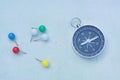 Compass and marking pins on white canvas background