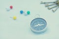 Compass and marking pins on white canvas background