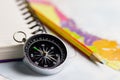 Compass notebook and pencil laid on a paper map.