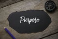 Compass,pencil and piece of black paper written with Purpose on wooden background Royalty Free Stock Photo