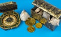 Compass and pirate coins on blue background Royalty Free Stock Photo