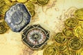 Compass and pirate golden coin on a old world map Royalty Free Stock Photo