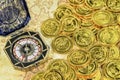 Compass and pirate golden coin on a old world map Royalty Free Stock Photo