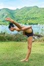 Compass pose variation or Surya Yantrasana yoga with ukrainian woman making it outdoors