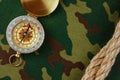 Compass and rope on a camouflage background