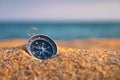 Compass on the sand close-up, sea in the background in sunset light. Finding navigation and paths. Sandy sea beach Royalty Free Stock Photo