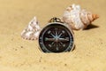 Compass and seashells on the sand at the beach Royalty Free Stock Photo