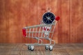 Compass and shopping cart on wooden background