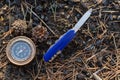 Compass and survival knife on background of earth. Royalty Free Stock Photo