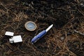 Compass, survival knife and lighter on ground in forest. Royalty Free Stock Photo