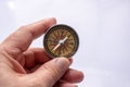 Compass tool in hand before a model house