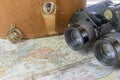 Compass and vintage binoculars sitting on old world map Royalty Free Stock Photo