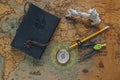 Compass, a vintage leather book, a branch of coral and a measuring tool with a pencil lie on an old map.