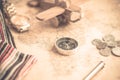 Compass on vintage world map with coins, pen, wrist watch, plane and flag for vacation and travel concept Royalty Free Stock Photo