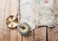 Compass on wooden desk with fake pirates treasure old map with red mark cross Royalty Free Stock Photo