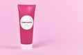 Compassion concept with cream tube with made up label saying `Compassion, 75ml cream` on pink background with copy space