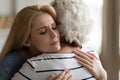 Empathic attractive young blonde woman hugging elderly mommy.