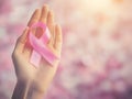 A compassionate gesture showcasing a pink ribbon in focus held in a hand to promote awareness and support. Health awareness Royalty Free Stock Photo