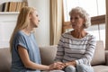 Compassionate grown up daughter listening to complaining old senior mother.