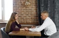 Compassionate male doctor holding hands with tense female patient and giving her psychological help