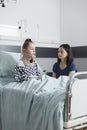 Compassionate uneasy mother spending time in hospital patient room with serious injured child