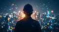 Silhouette engineer in hard hat overlooks futuristic digital city network at night. Royalty Free Stock Photo