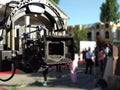 Compendium with cinema camera on flying head. Flying camera stopped after shooting on stage with urban background. Front side of