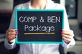 Compensation and benefits at job concept with comp and ben text written on cardboard hold by employee