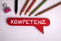 Competence Concept. Text on red speech bubble in german language. Office desk Royalty Free Stock Photo