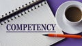 COMPETENCY - word in a white notebook on a purple background with a cup of coffee